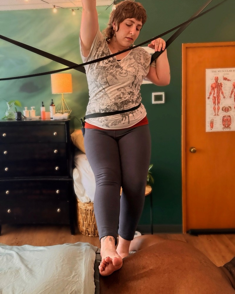 Sabrielle performing Ashiatsu using overhead support bars.